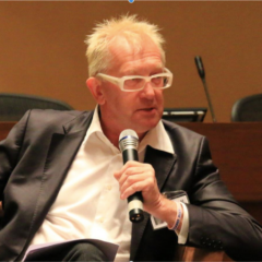 Photo of Sam Winter seated, speaking into a microphone