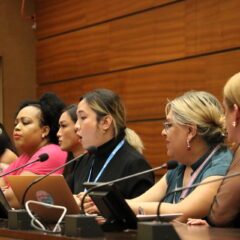 Six trans activists sitting side by side in front of microphones speaking at a side event at the UN 53rd Session of Human Rights Council 2023