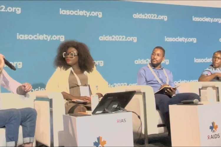 Four transgender people sitting on a stage at AIDS 2022 presenting at a satellite symposium.