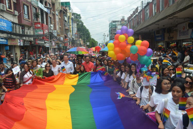 Hundreds of people holding an LGBTQI flag at Gaijatra Nepal Pride