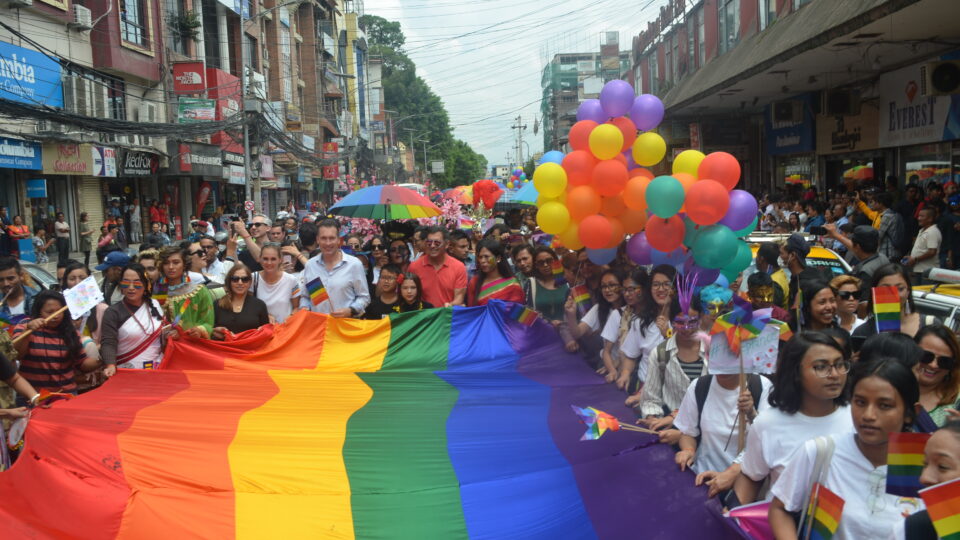 Hundreds of people holding an LGBTQI flag at Gaijatra Nepal Pride